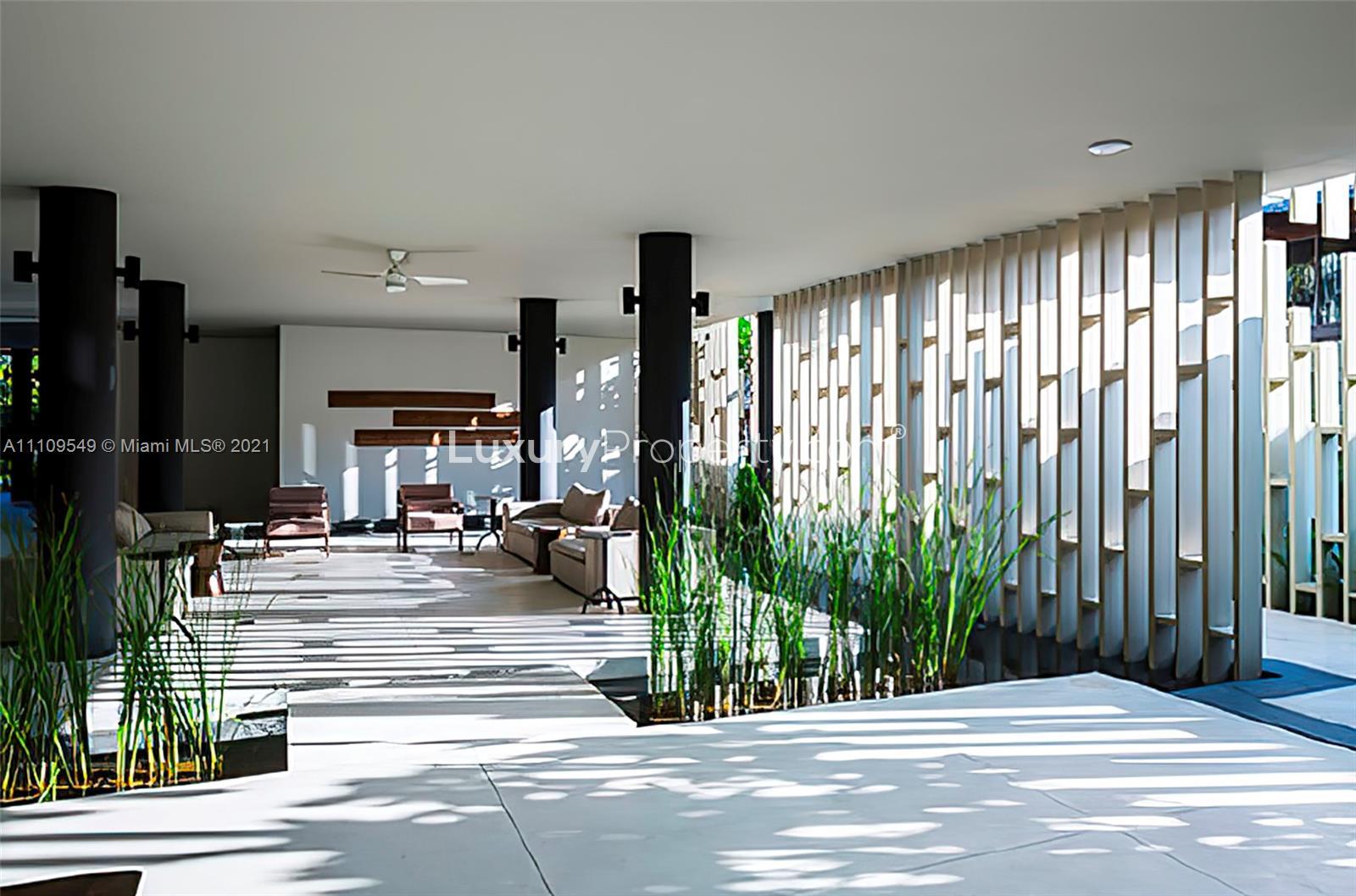 Furnished 8-bedroom villa exterior with lush landscaping, for sale in Miami, Florida