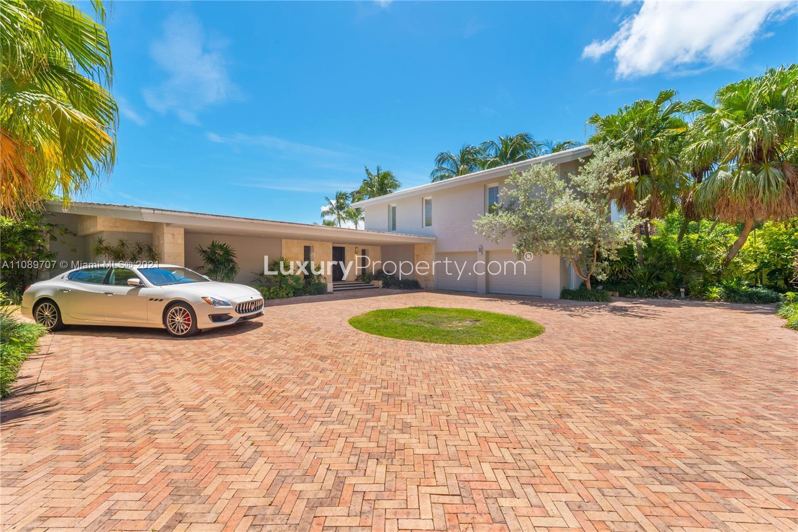 Bay View 900 Harbor Drive Miami villa entrance with lush greenery and brick driveway