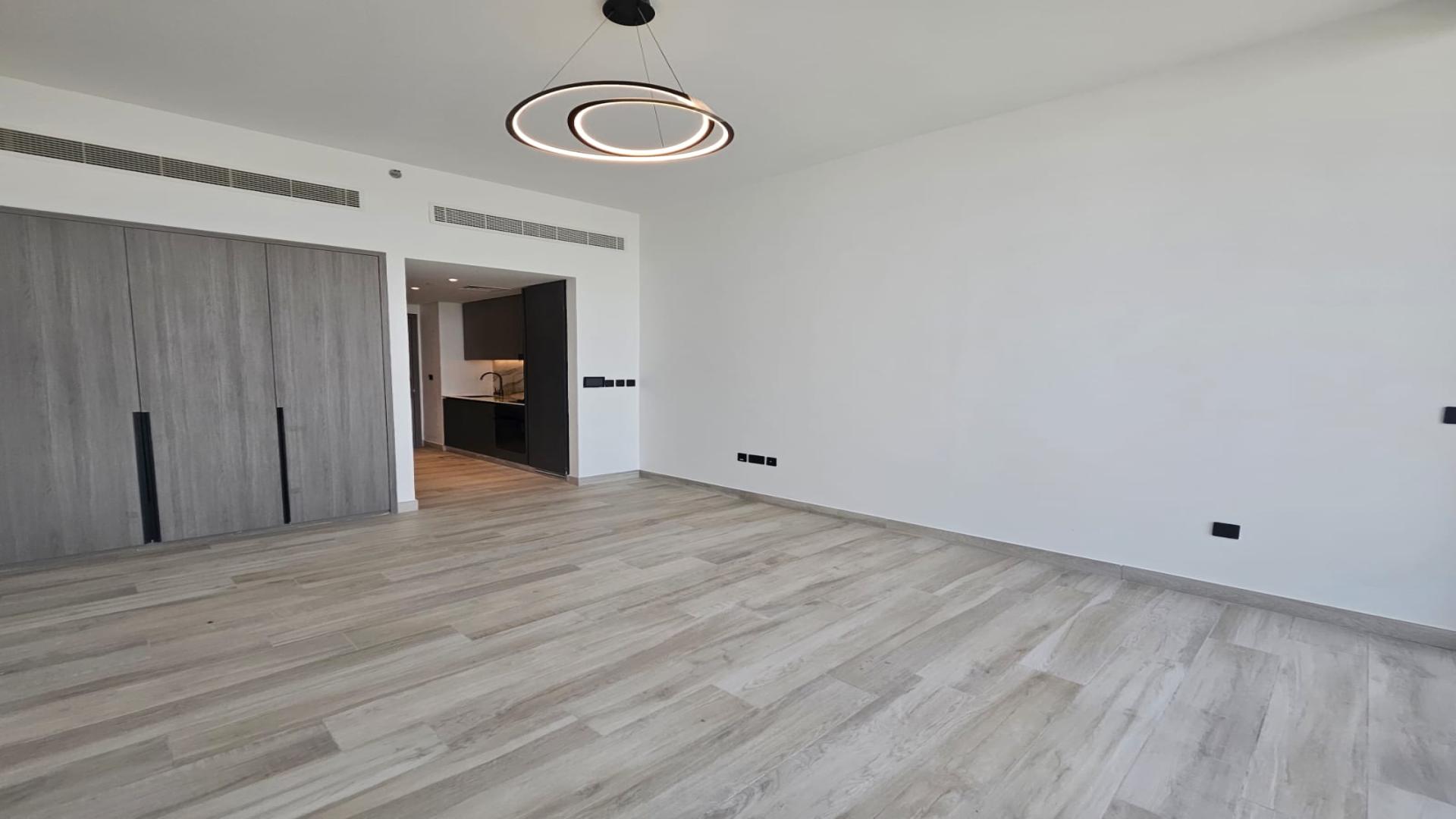 Studio apartment interior at Oxford Gardens, Arjan with modern lighting and wooden flooring