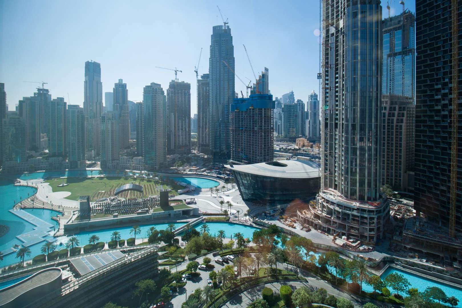 Aerial view of Downtown Dubai near Burj Khalifa, showcasing lush gardens and skyscrapers