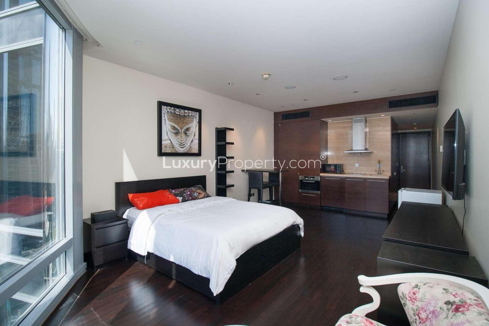 Skyline view from Burj Khalifa studio apartment, Downtown Dubai, overlooking cityscape and fountains