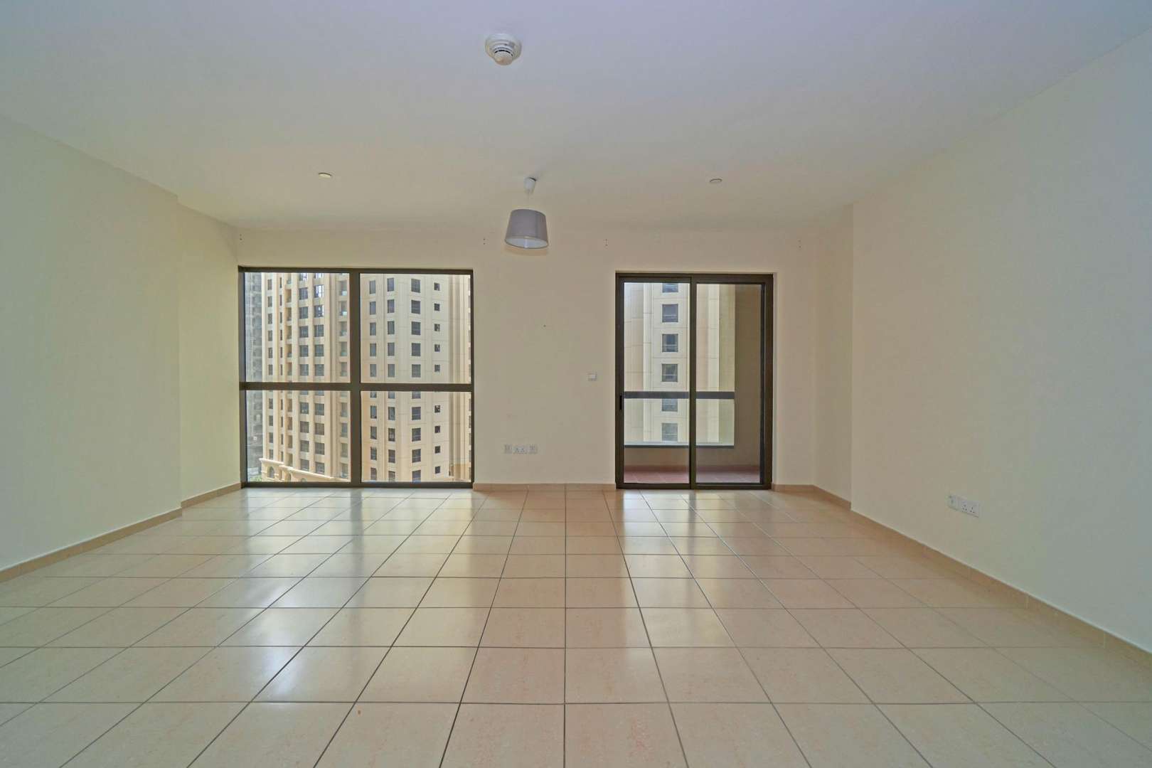 Studio apartment kitchen with wooden cabinets and balcony view, Jumeirah Beach Residence