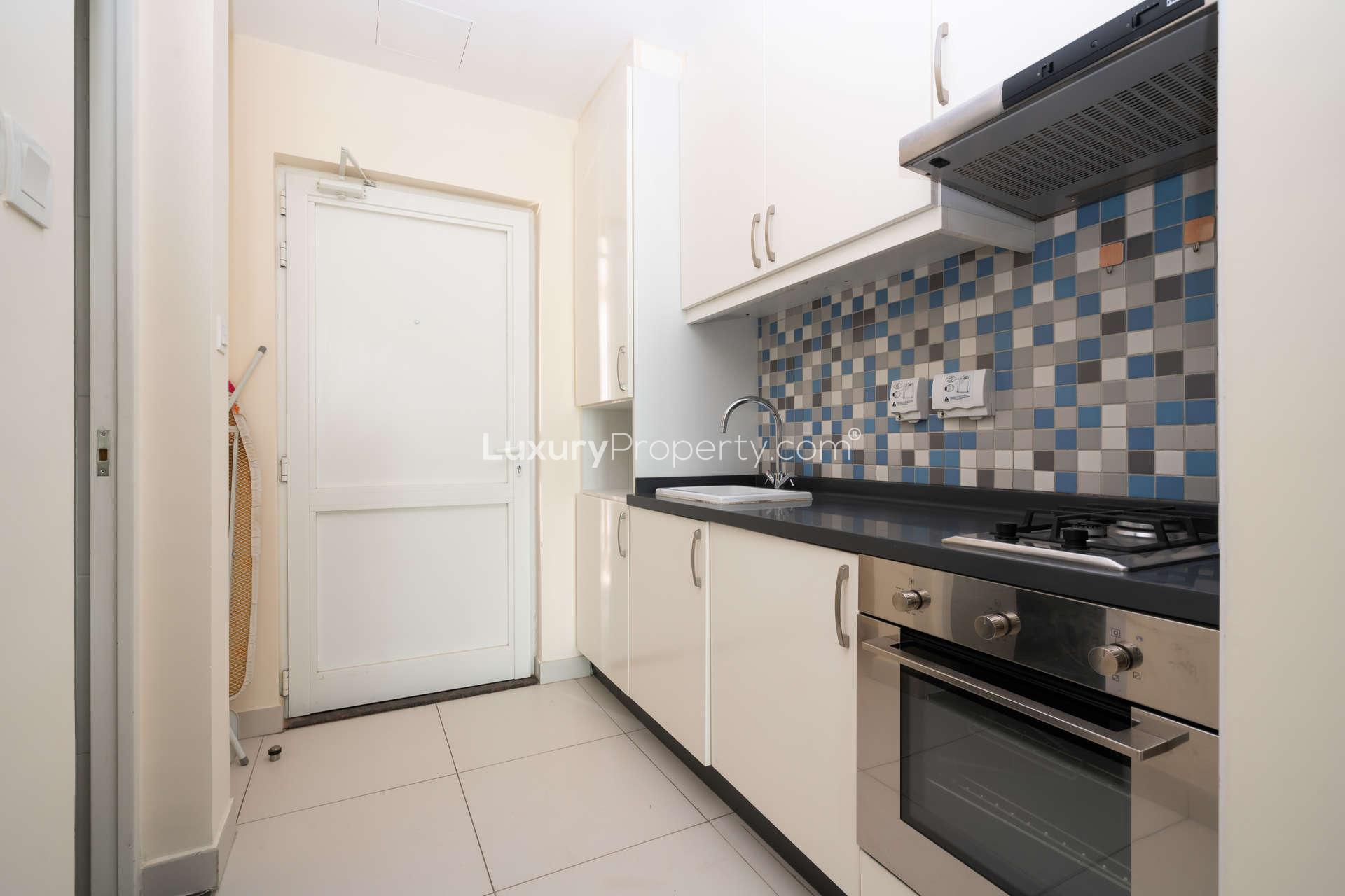 Modern kitchen in fully furnished studio apartment, Palm Jumeirah, with tiled backsplash and appliances