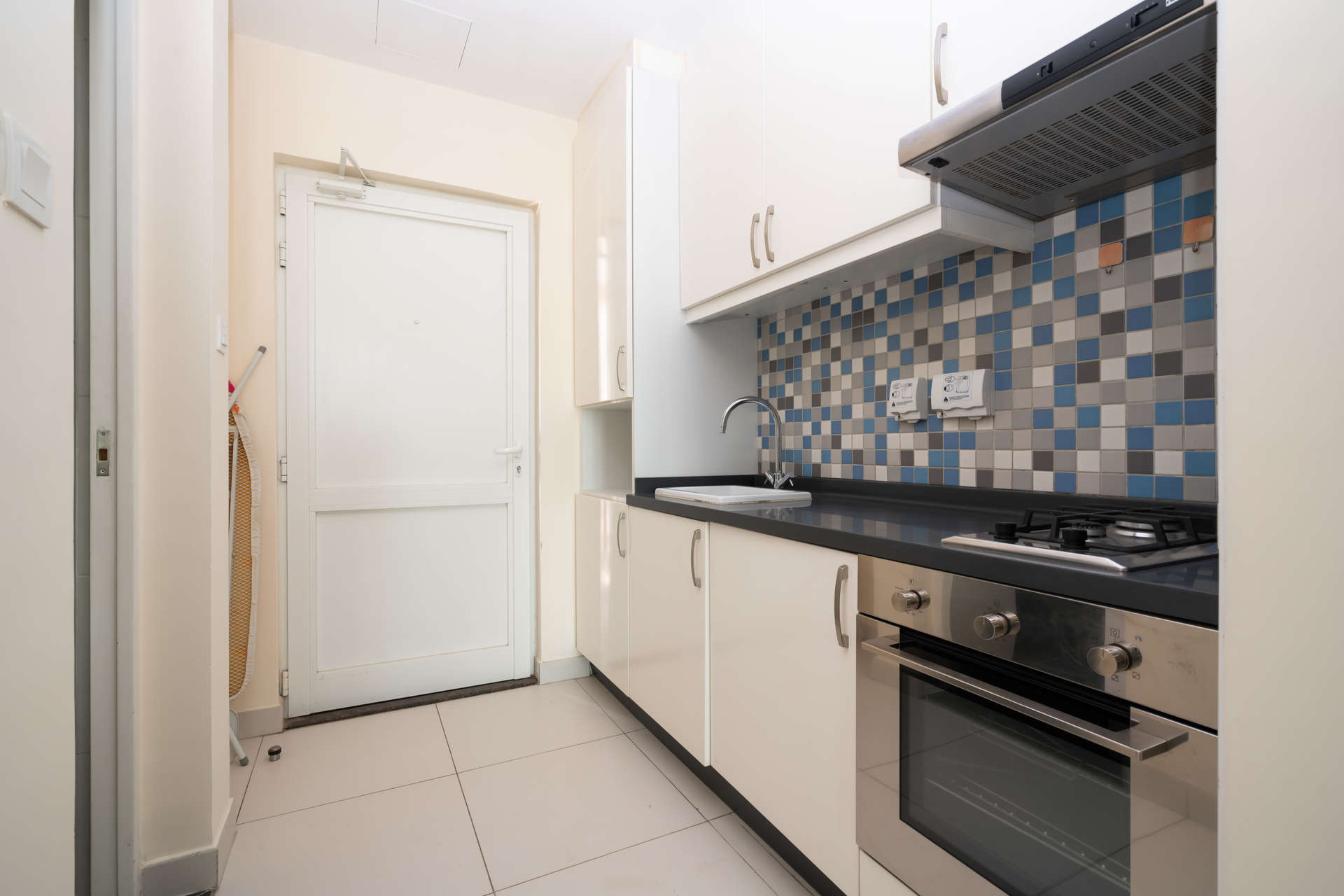 Modern kitchen in fully furnished studio apartment, Palm Jumeirah, with tiled backsplash and appliances