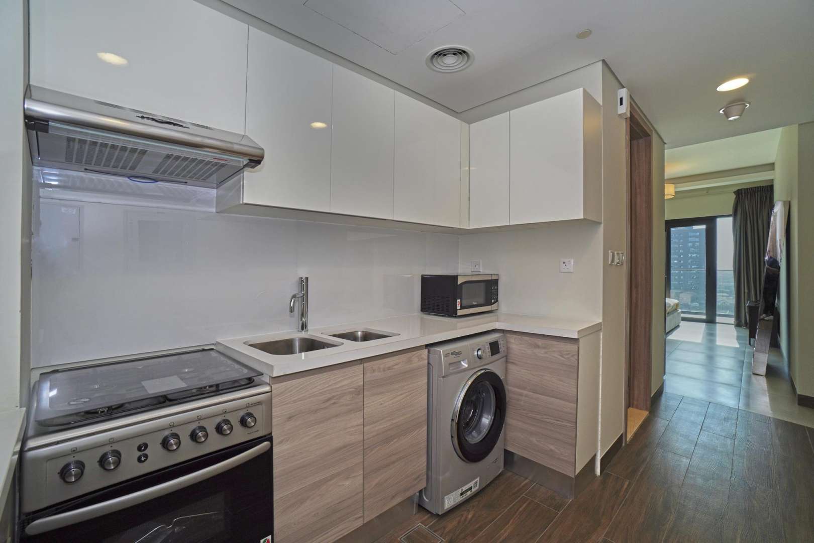 Modern kitchen in SOL Bay studio apartment, Business Bay, featuring appliances and sleek cabinetry