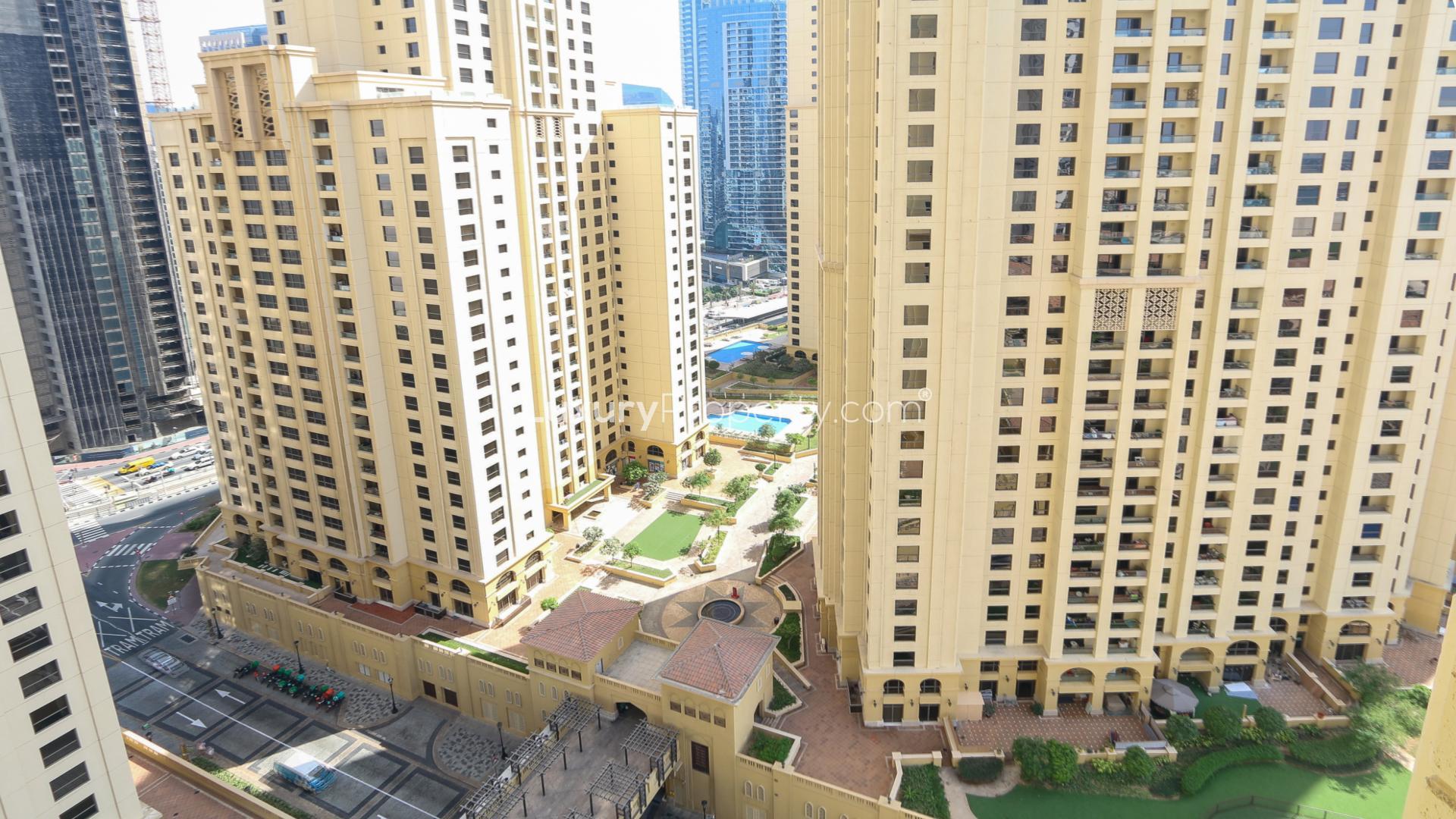 Empty studio apartment interior with large windows, tiled floors, and Marina views in JBR Murjan