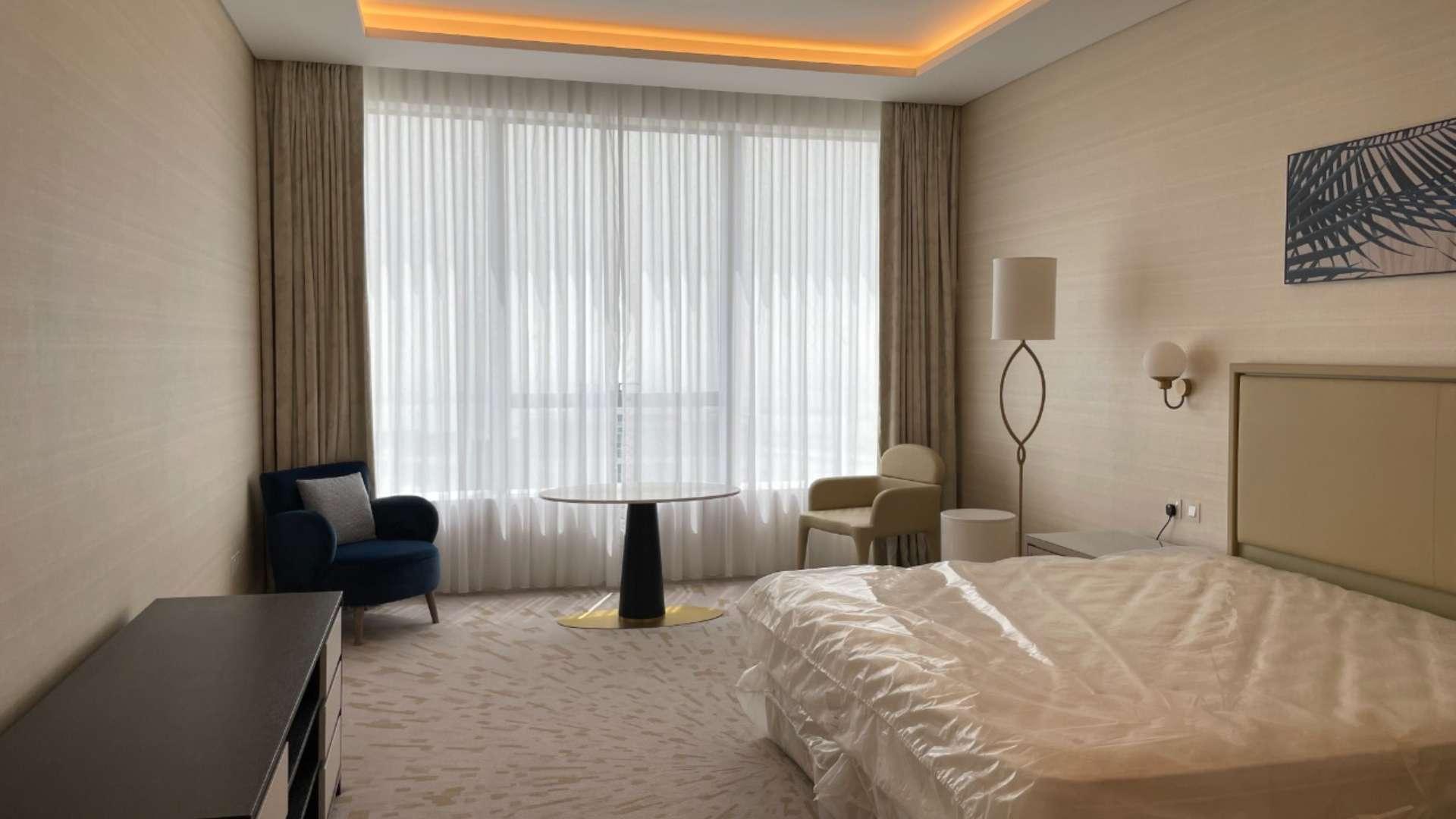 Modern kitchenette in luxurious Palm Jumeirah studio apartment, featuring sleek wooden cabinetry