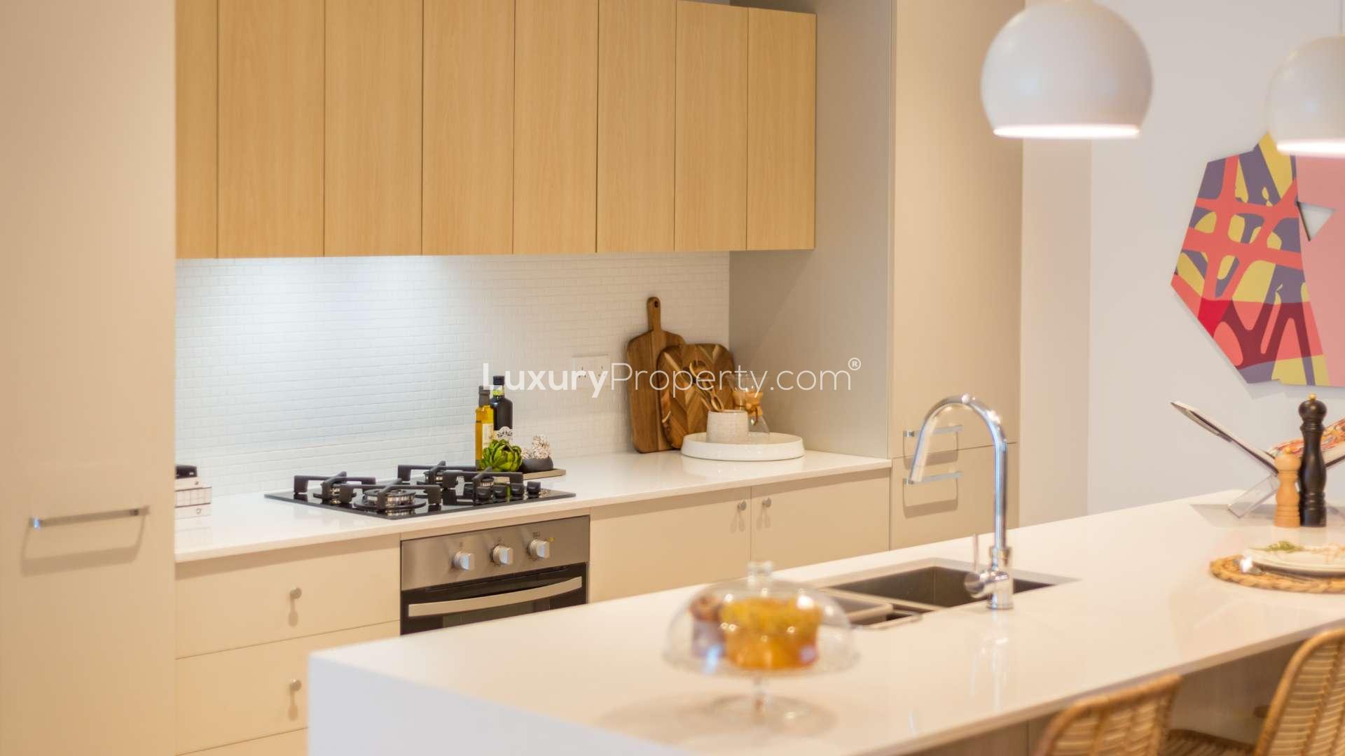 Luxurious studio kitchen with modern appliances in The Sloane, Jumeirah Village Circle apartment