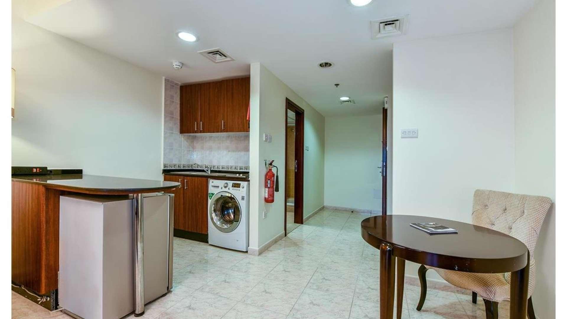 Fully furnished studio apartment interior in Dubai Marina, featuring cozy living area and workspace