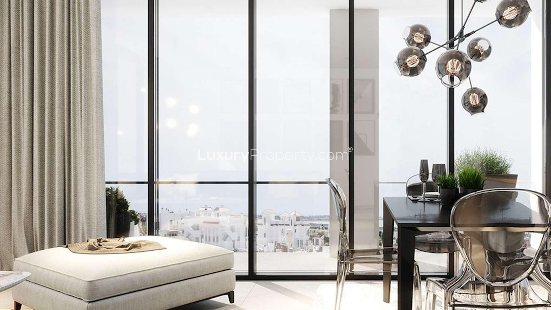 Modern apartment interior with large windows, stylish furniture, and city view in Aljada, Sharjah