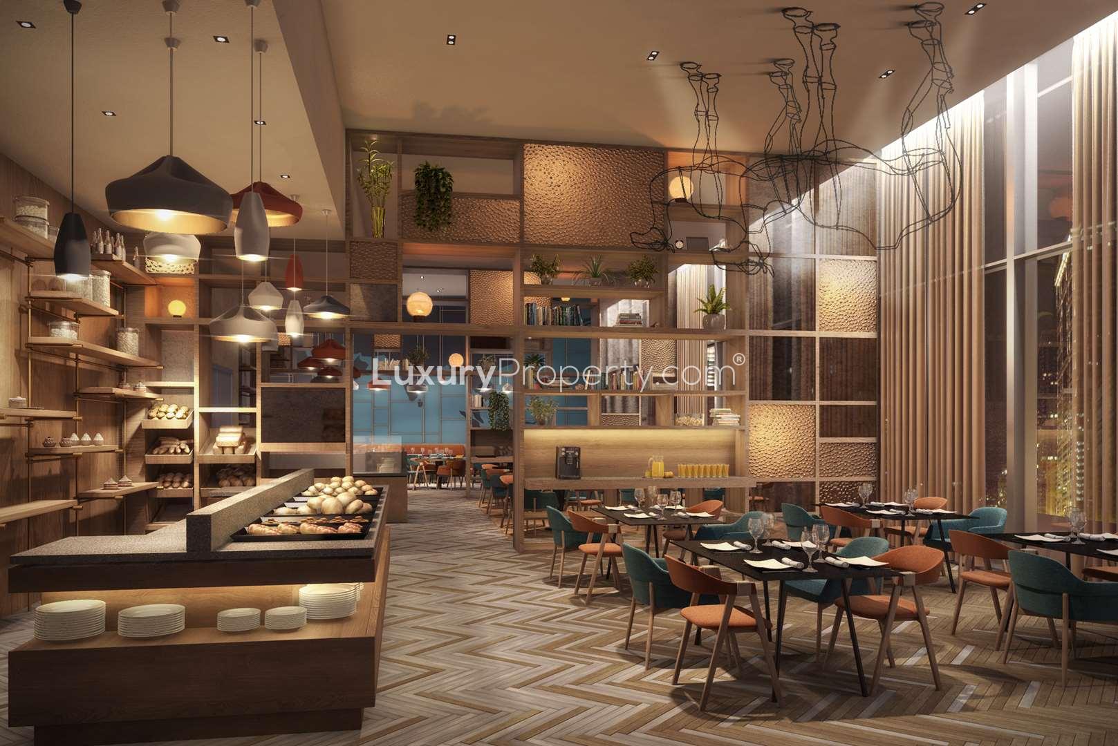 Tall modern apartment building in Cayan Cantara, Al Barsha South, Dubai, surrounded by palm trees