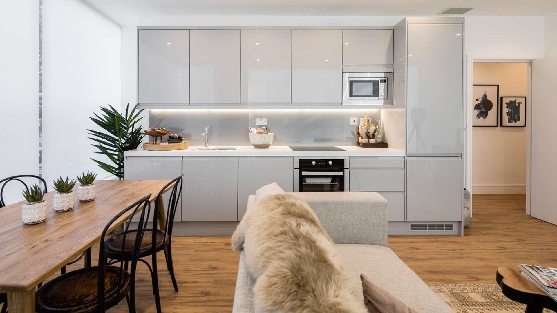Modern living room in Westgate House apartment, featuring sleek kitchen and cozy furnishings