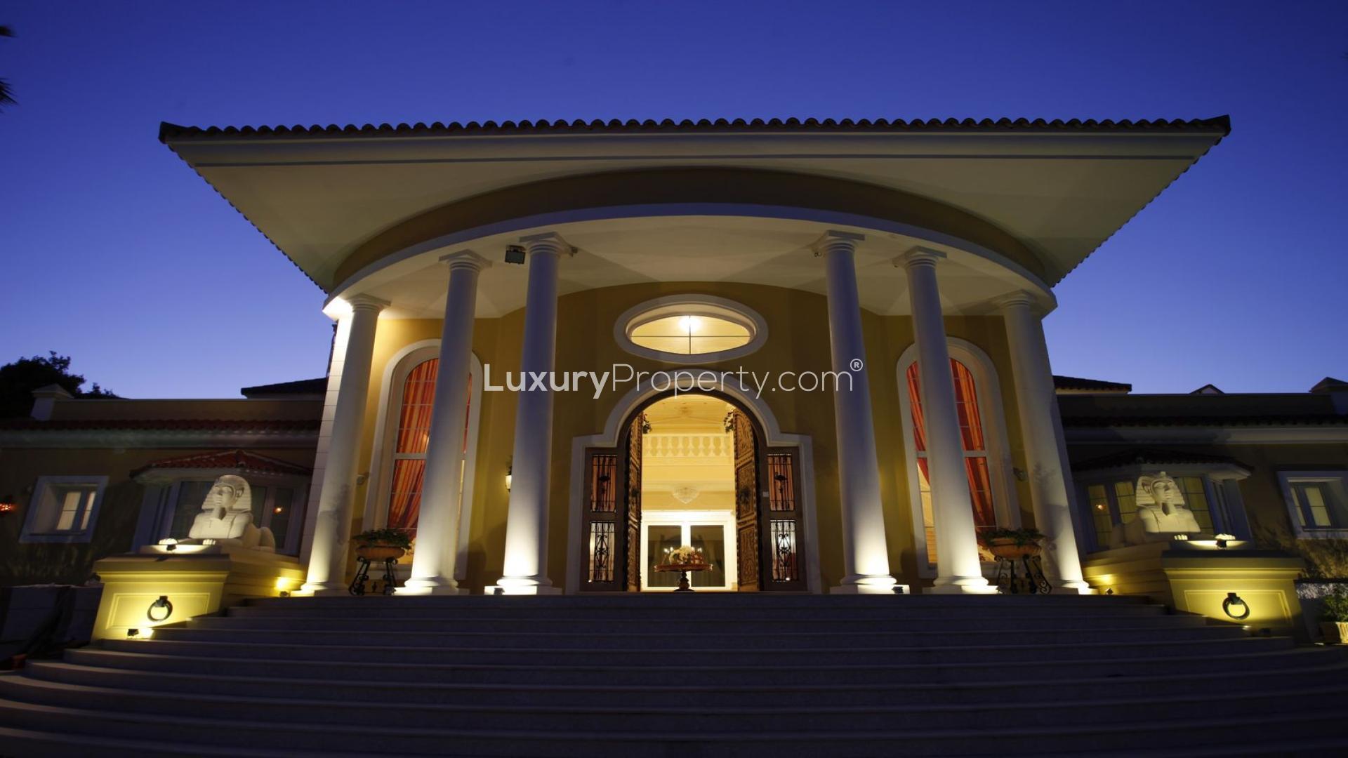 Elegant 6-bedroom villa exterior in Sotogrande, Spain with gated entrance and palm trees