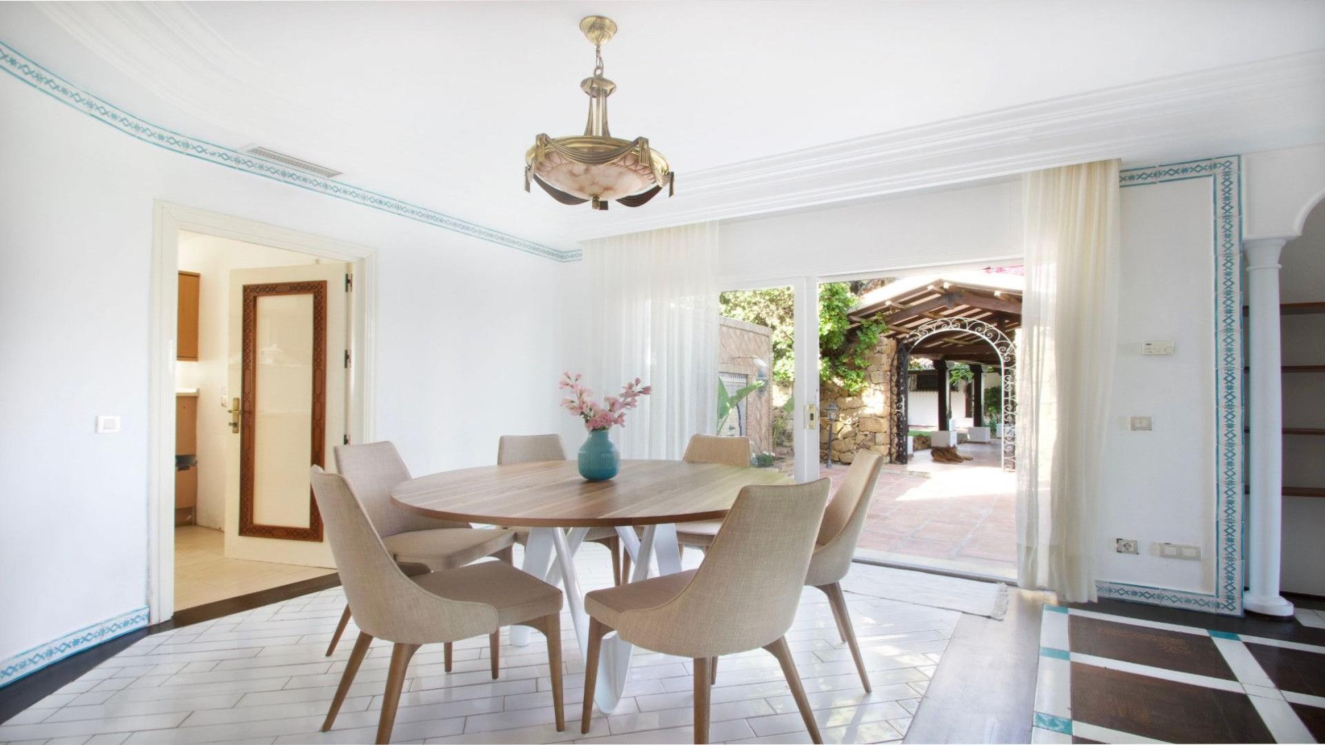 Andalusian-style villa living room with large sofa, elegant decor, and natural light in Marbella