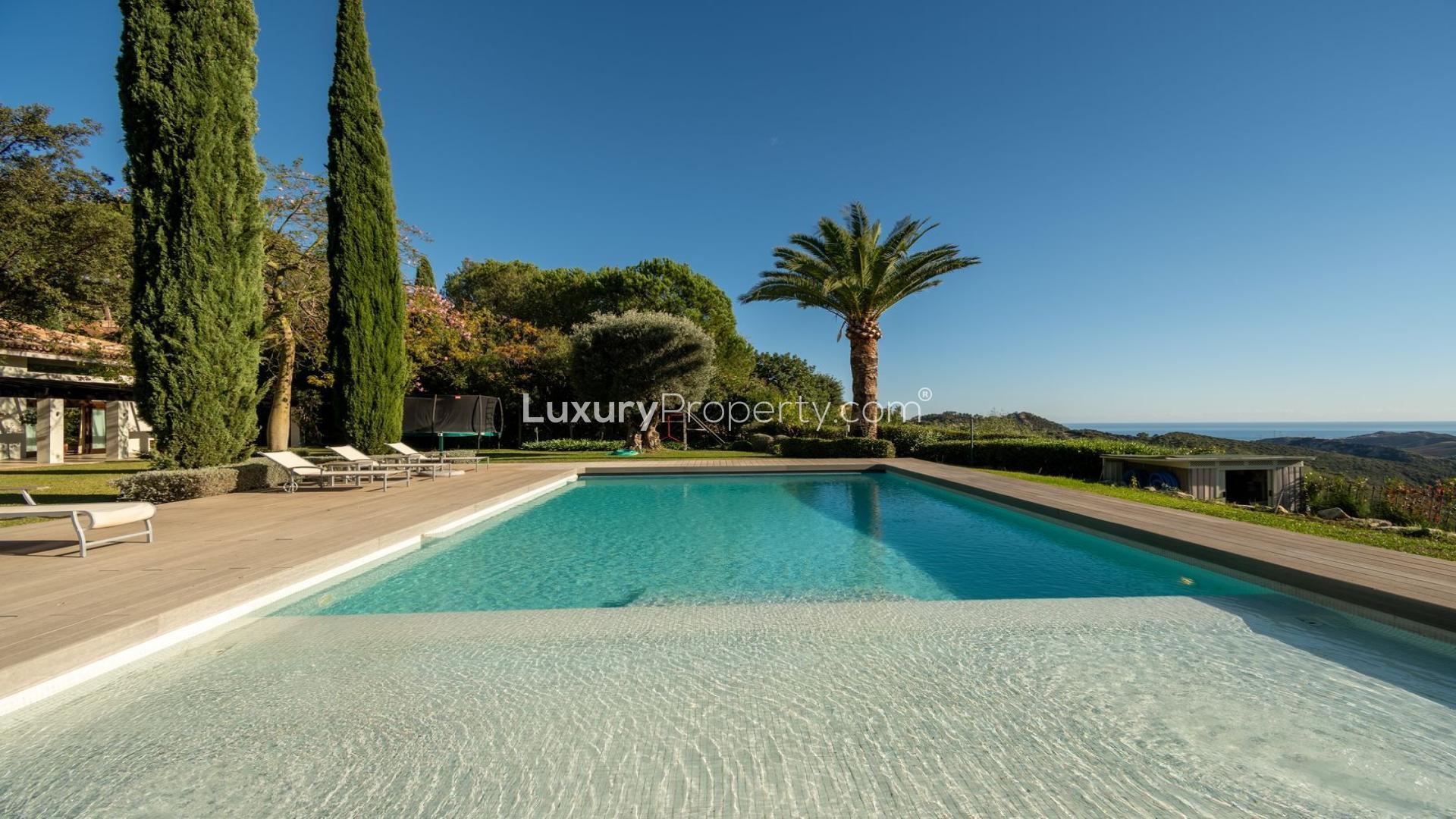 Luxury villa with pool in La Zagaleta, Málaga, surrounded by lush greenery and loungers