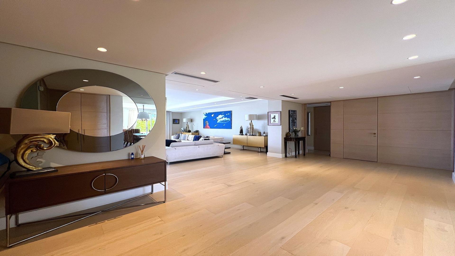 Aerial view of Puerto Banús penthouse, lush gardens, pool, and beach backdrop