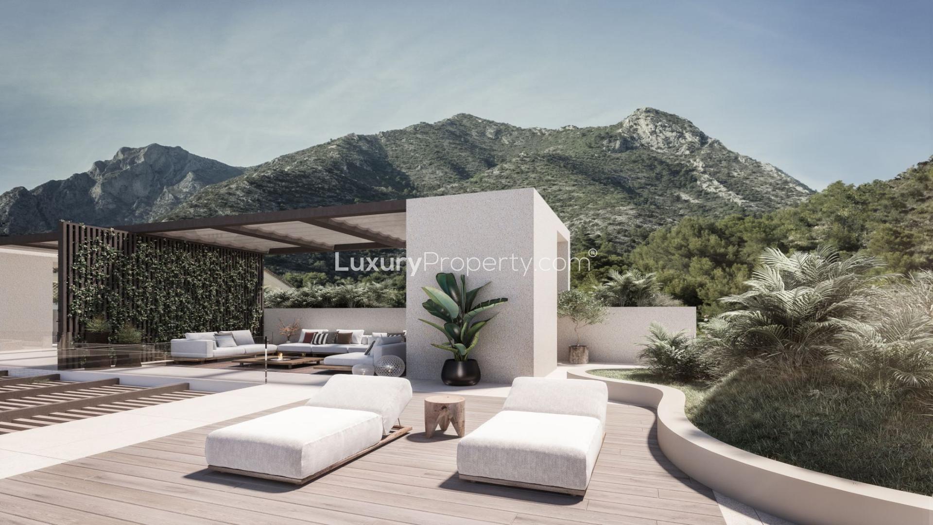 Rooftop terrace of Marbella villa with pool, sun loungers, and coastal view
