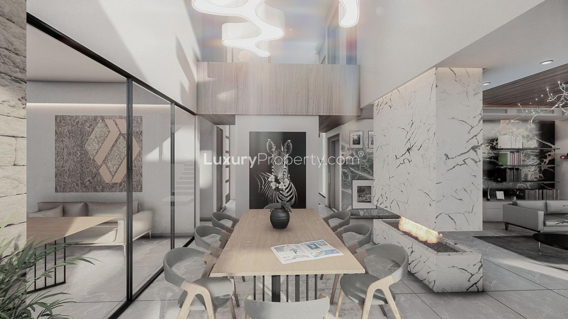 Modern luxury villa living room with fireplace, elegant decor, and pool view in La Alquería