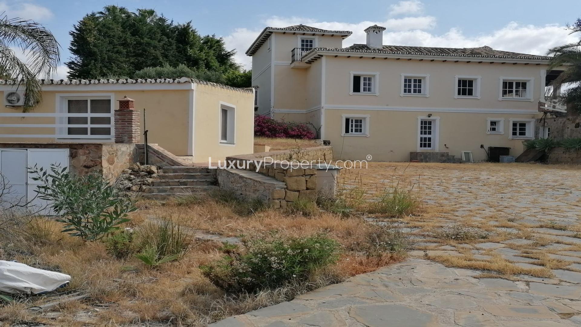 Exterior view of luxury villa for sale in La Quinta, Málaga, with vibrant garden