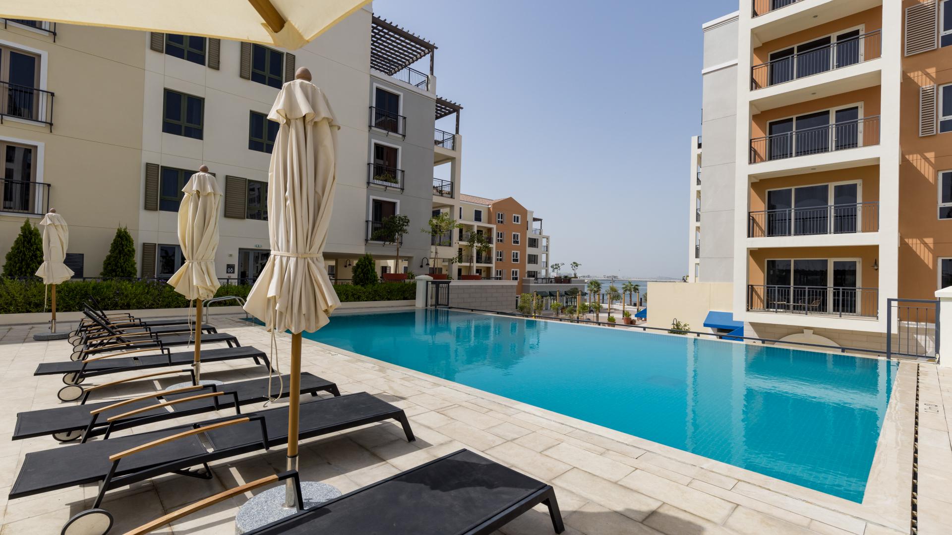 Modern residential building exterior with landscaped courtyard in La Mer, Jumeirah, Dubai real estate