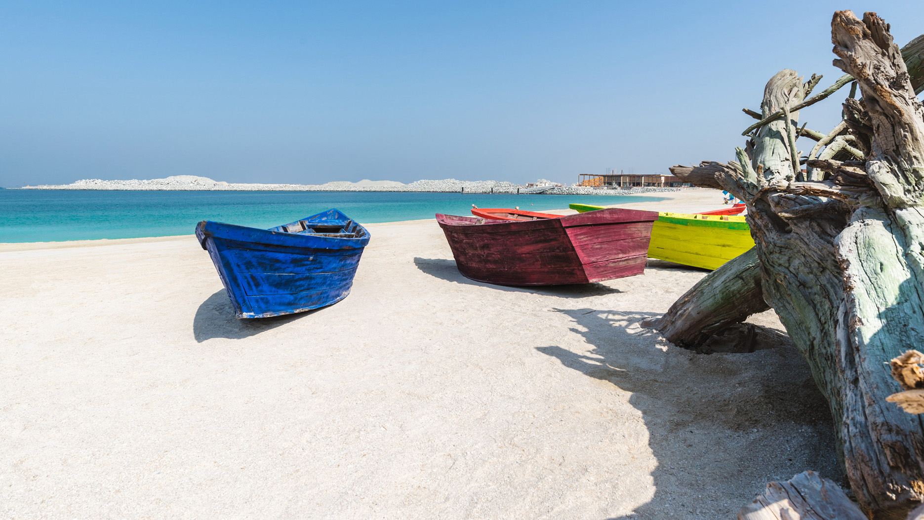Beachfront view of La Mer South, Jumeirah, Dubai with hammocks and sandy shore