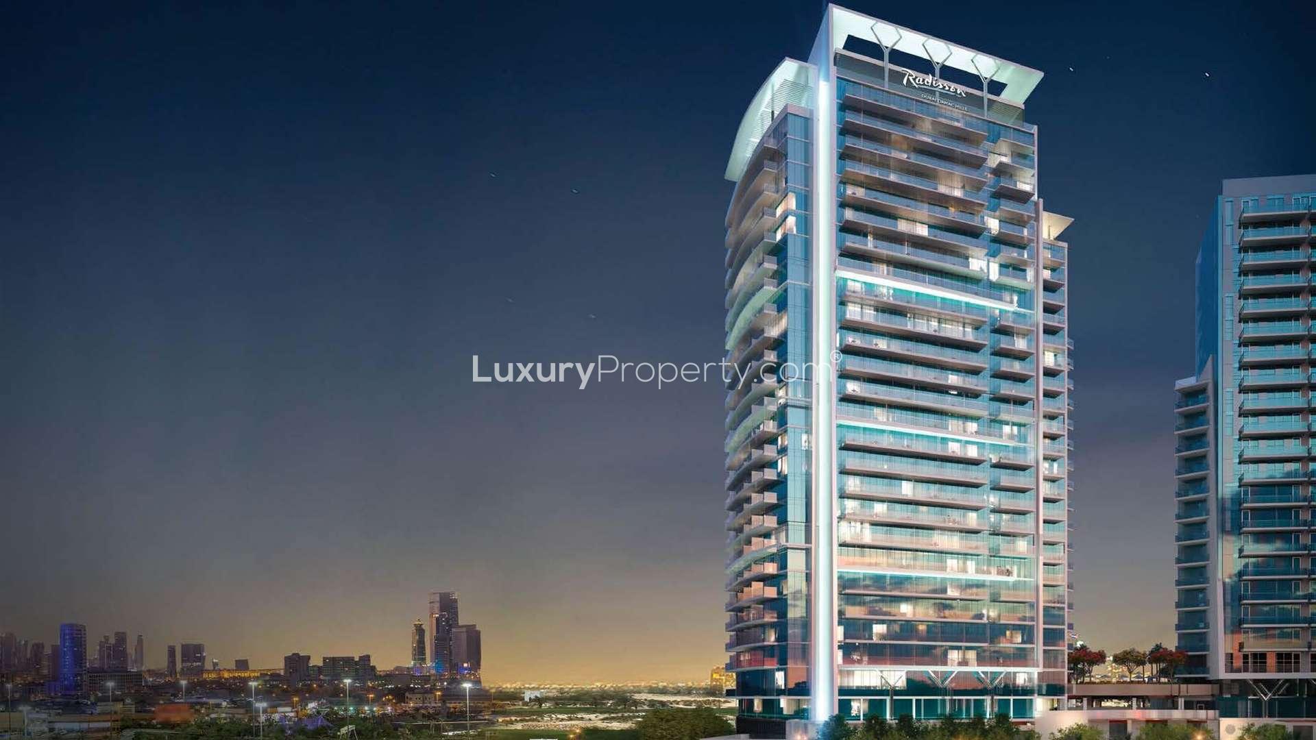 Outdoor pool area at Radisson Dubai DAMAC Hills apartment, lush landscaping, modern design