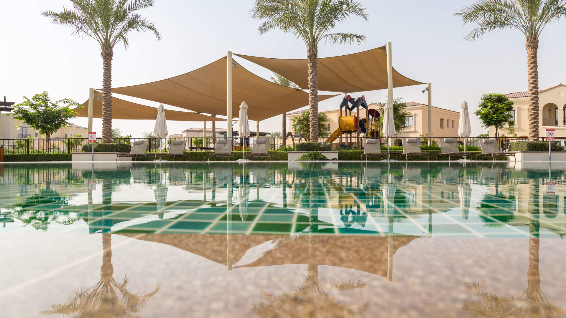 Charming Lila Villas entrance with palm trees, Arabian Ranches 2, Dubai. For sale