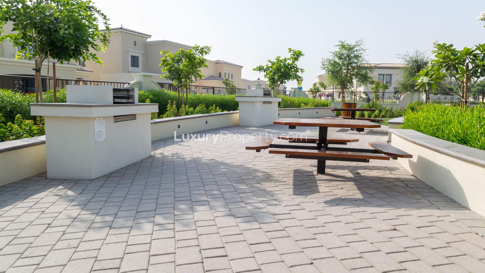 "Entrance sign for Rasha Villas in Arabian Ranches 2, elegant Spanish-style residences.",Outdoor seating and barbecue area at Rasha Villas, Arabian Ranches 2, for sale