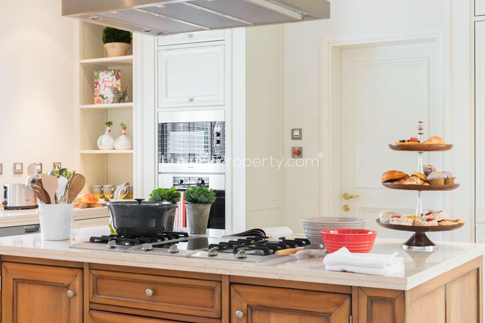 Elegant dining area in Redwood Avenue villa, Jumeirah Golf Estates, overlooking lush garden