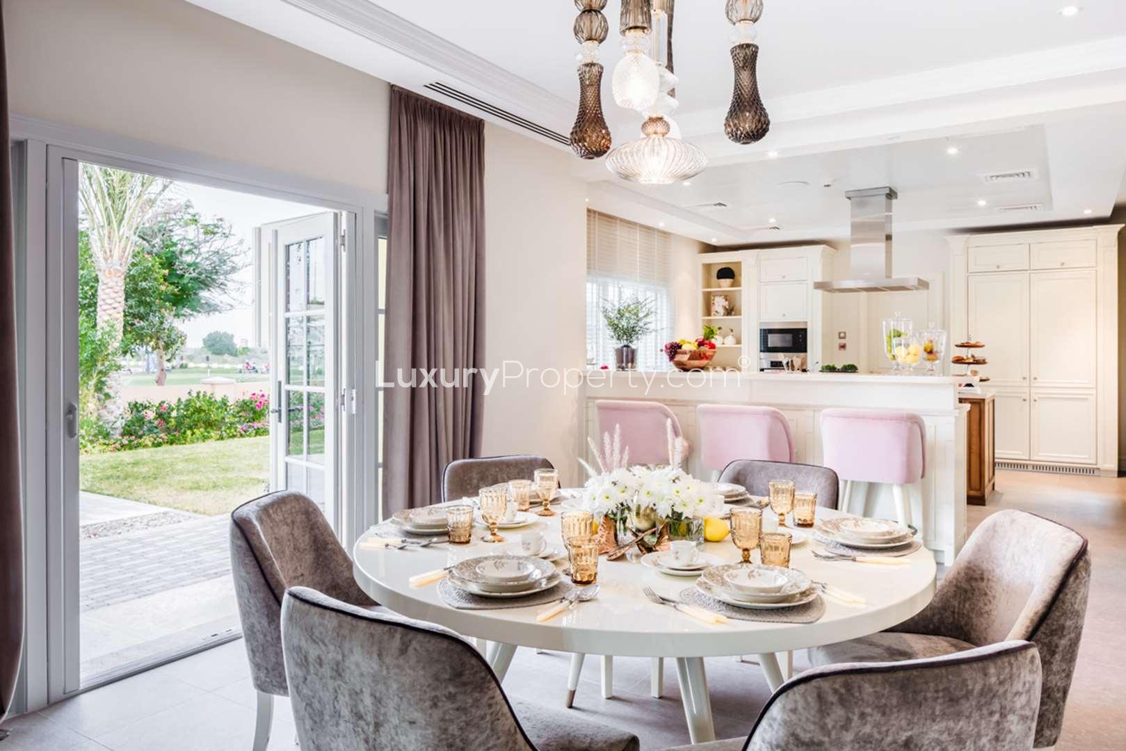 Elegant dining area in Redwood Avenue villa, Jumeirah Golf Estates, with garden view