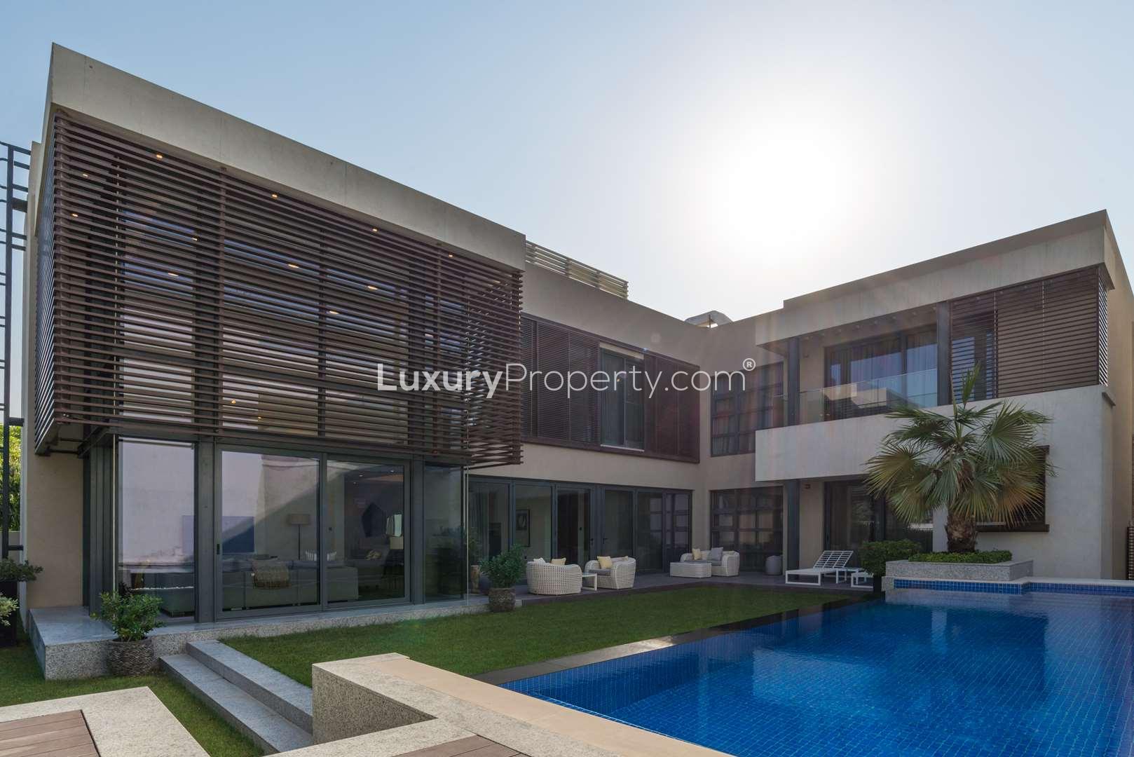 Modern villa exterior at Sobha Hartland Estate, MBR City, featuring lush garden and pool
