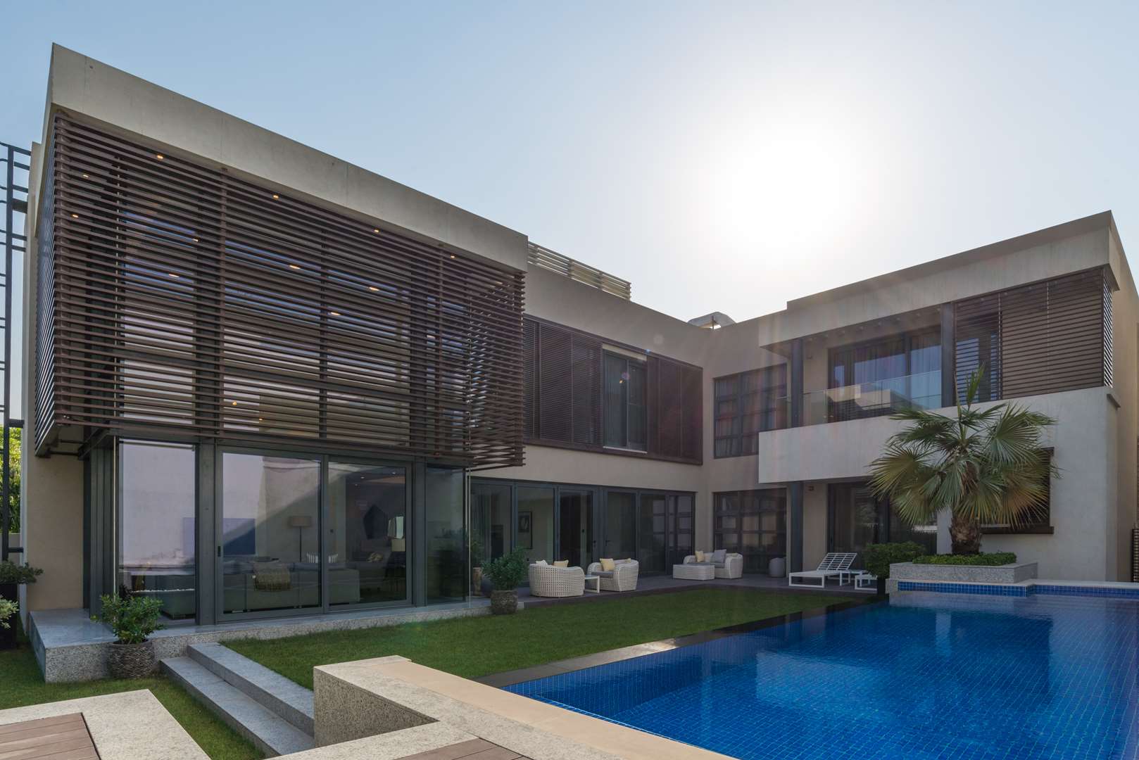 Modern villa exterior at Sobha Hartland Estate, MBR City, featuring lush garden and pool